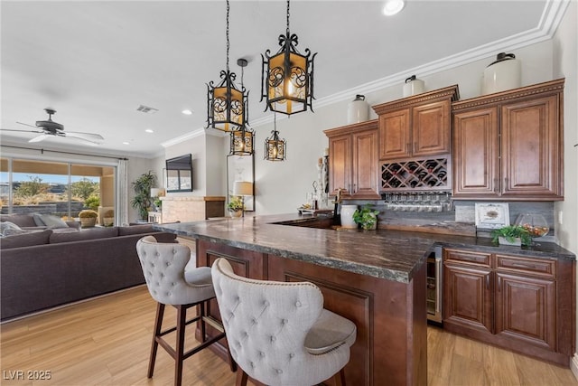 kitchen featuring tasteful backsplash, light hardwood / wood-style flooring, ceiling fan, and pendant lighting