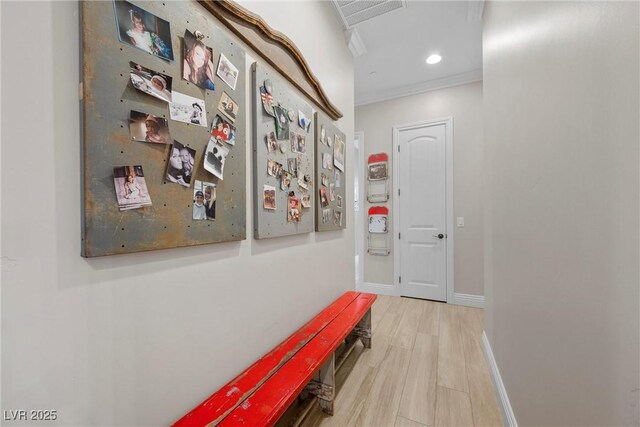 hall with crown molding and light hardwood / wood-style floors