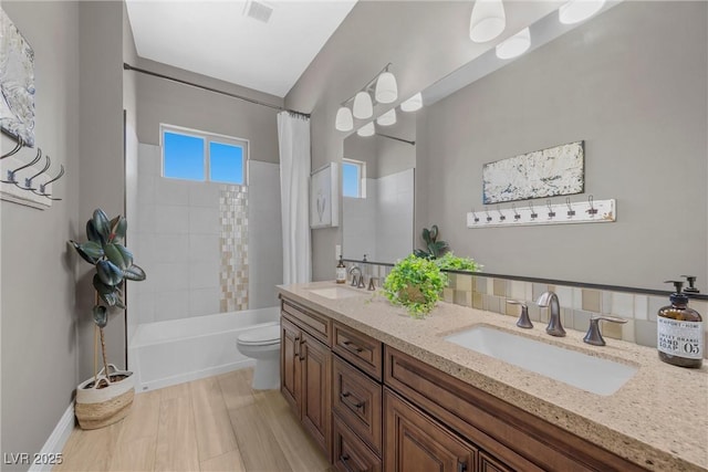 full bathroom featuring hardwood / wood-style flooring, toilet, vanity, and shower / tub combo with curtain