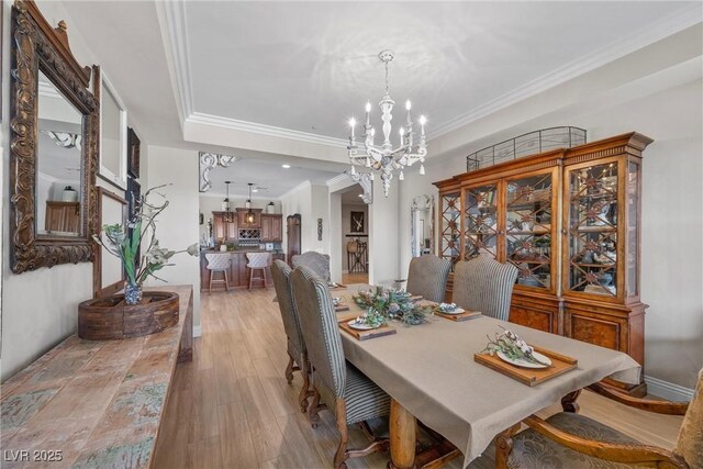 dining room featuring a chandelier, crown molding, and light hardwood / wood-style flooring