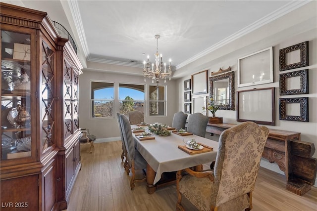 dining space with an inviting chandelier, ornamental molding, and light hardwood / wood-style flooring