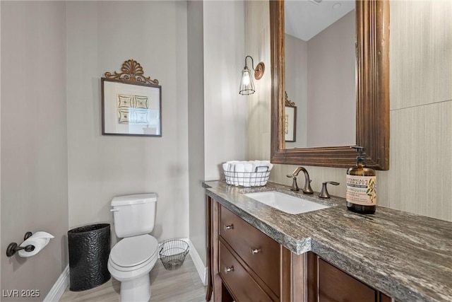 bathroom featuring hardwood / wood-style flooring, toilet, and vanity