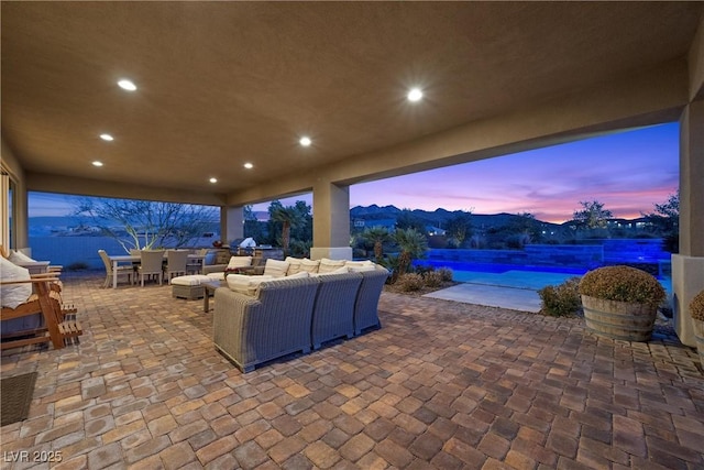 patio terrace at dusk with a mountain view and an outdoor living space