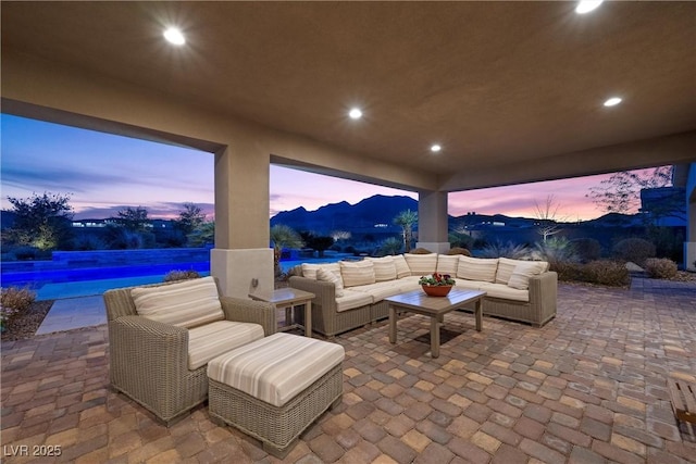 patio terrace at dusk featuring an outdoor living space and a mountain view