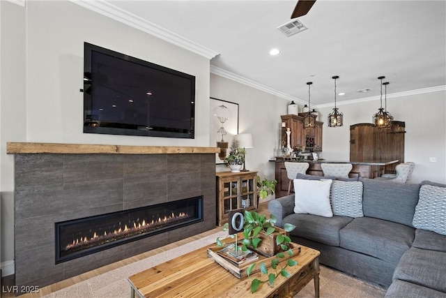 living room with a fireplace and crown molding