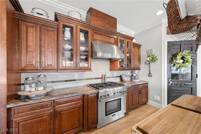 kitchen featuring light stone countertops, wall chimney exhaust hood, light hardwood / wood-style floors, and high end stove