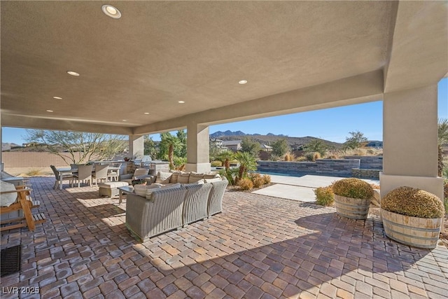 view of patio with an outdoor living space, a grill, and a mountain view