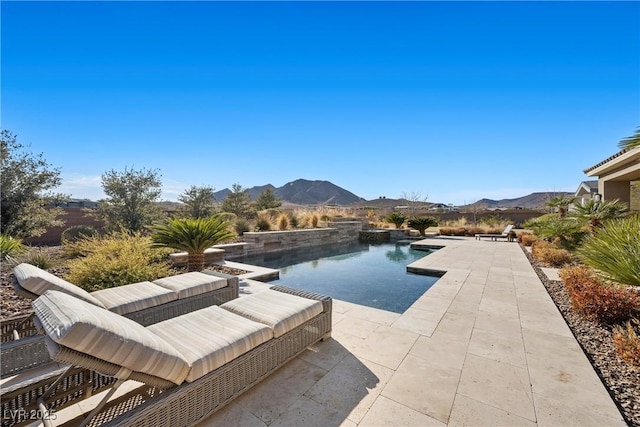 view of swimming pool with a mountain view and a patio