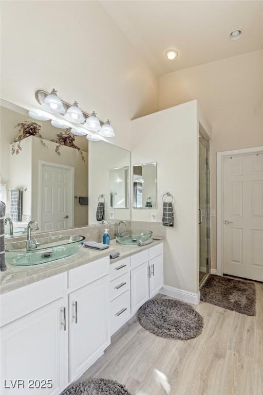 bathroom with high vaulted ceiling, an enclosed shower, wood-type flooring, and vanity