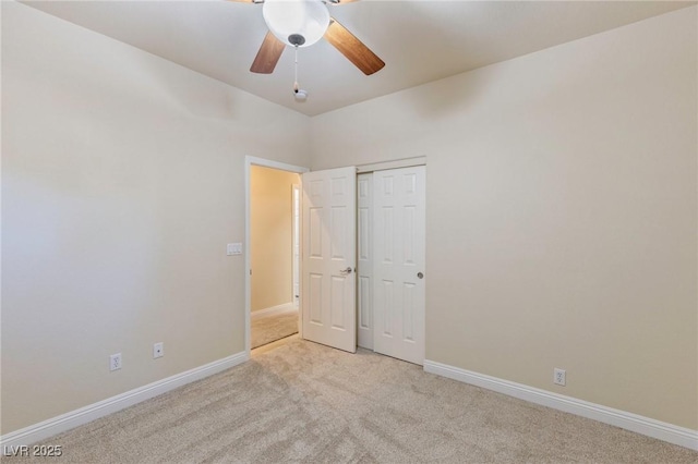 unfurnished bedroom with ceiling fan, light colored carpet, and a closet