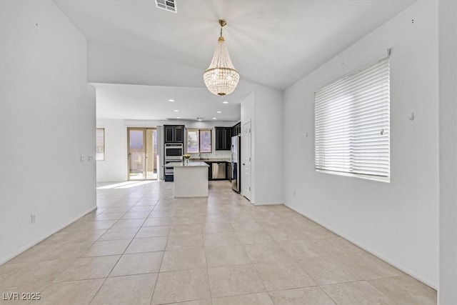 interior space featuring a notable chandelier, a wealth of natural light, and light tile patterned floors