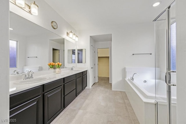 bathroom with vanity, tiled tub, and tile patterned floors