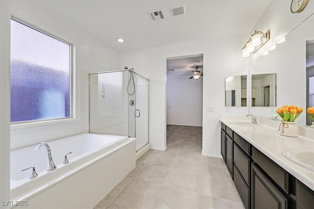 bathroom with a healthy amount of sunlight, separate shower and tub, vanity, and ceiling fan