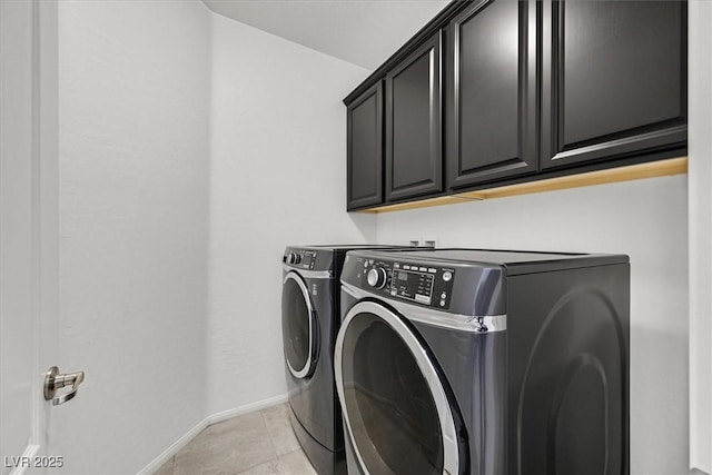 laundry room with cabinets, washing machine and clothes dryer, and light tile patterned floors