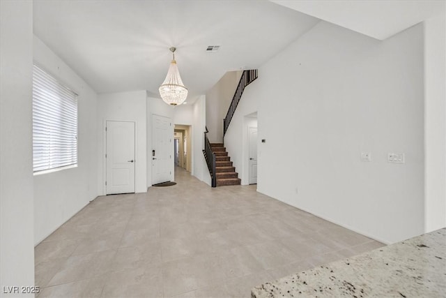 unfurnished room with a notable chandelier