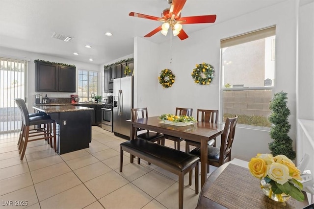 dining space with ceiling fan and light tile patterned floors