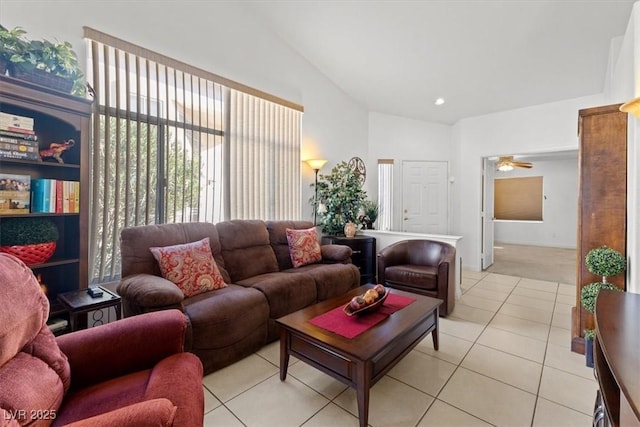 living room featuring lofted ceiling, ceiling fan, and light tile patterned flooring