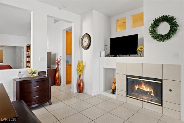 living room featuring a tiled fireplace, light tile patterned floors, and built in features