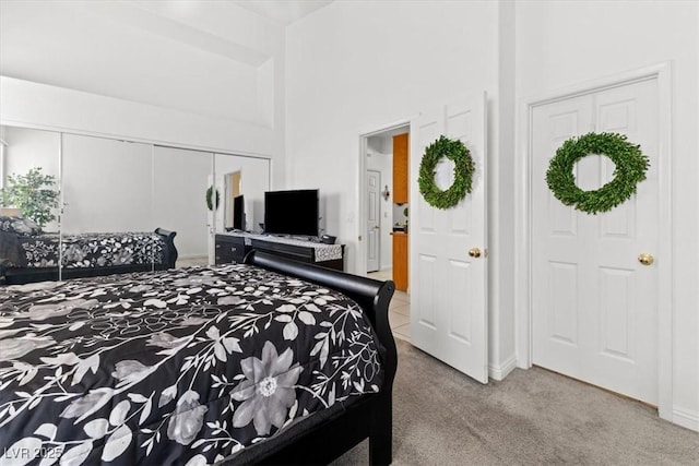 bedroom with a high ceiling, light colored carpet, and a closet