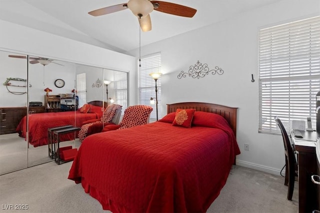 bedroom with ceiling fan, vaulted ceiling, light carpet, and a closet