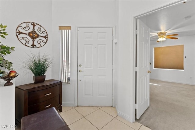 foyer featuring ceiling fan and light colored carpet