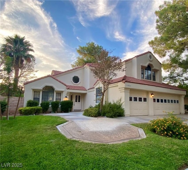 mediterranean / spanish-style home featuring a front yard and a garage