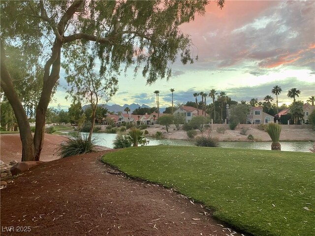 view of community with a yard and a water view