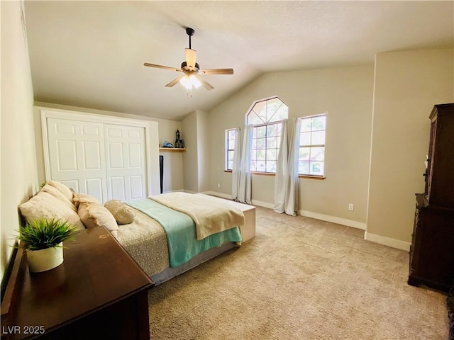 bedroom featuring lofted ceiling, light colored carpet, ceiling fan, and a closet