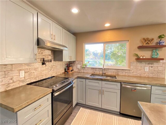 kitchen featuring appliances with stainless steel finishes, decorative backsplash, and sink