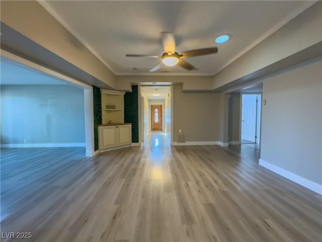 unfurnished living room featuring crown molding, ceiling fan, and light hardwood / wood-style flooring