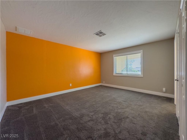 spare room with dark colored carpet