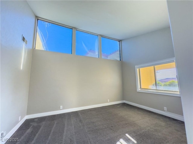 spare room featuring dark colored carpet