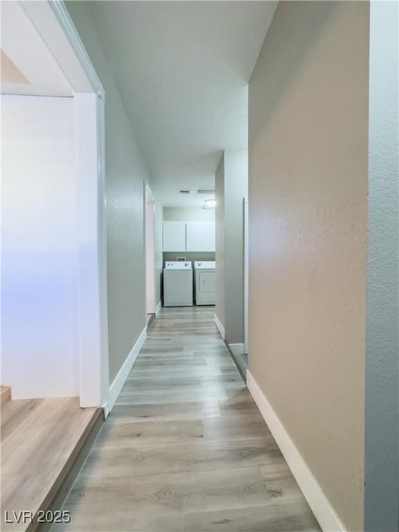 hall featuring washing machine and dryer and light hardwood / wood-style flooring