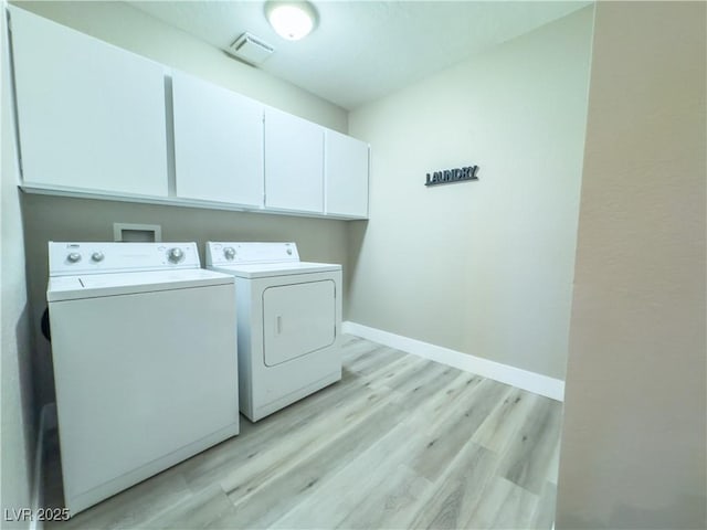 clothes washing area with light hardwood / wood-style flooring, cabinets, and independent washer and dryer