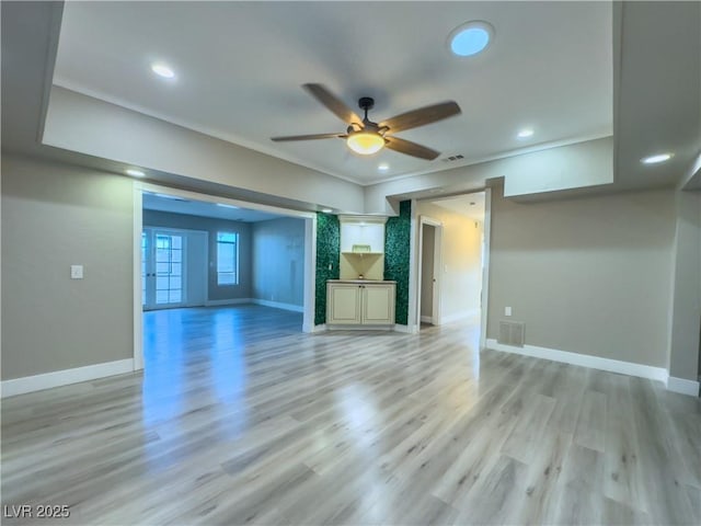 unfurnished living room with ceiling fan, light hardwood / wood-style floors, and crown molding