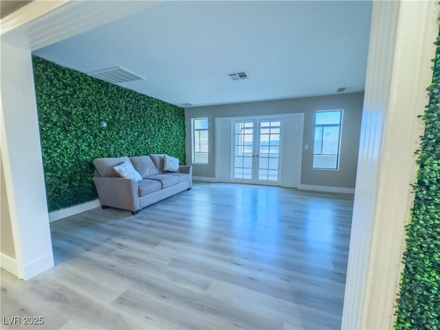 unfurnished living room with french doors and hardwood / wood-style floors