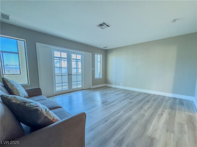 unfurnished living room featuring light hardwood / wood-style flooring and french doors