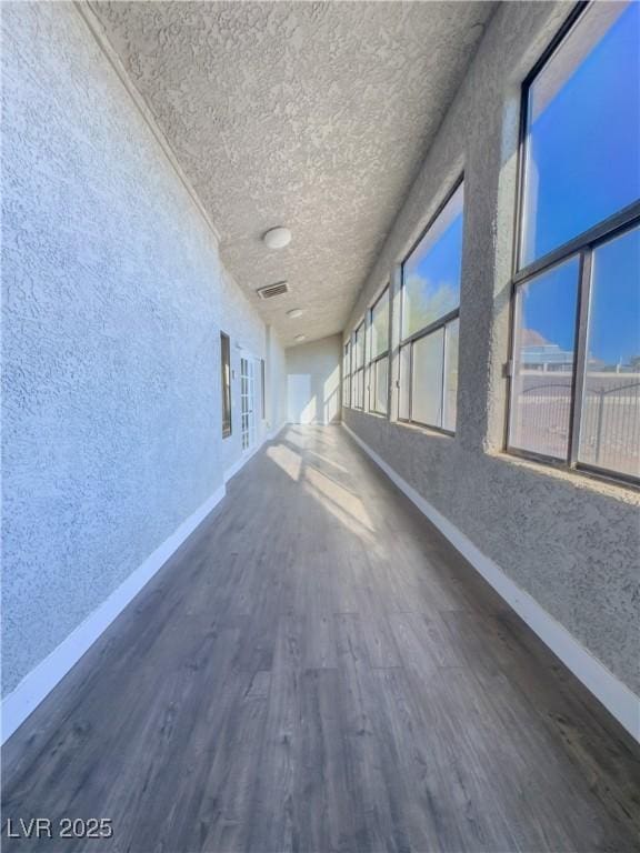 hall with dark wood-type flooring and a textured ceiling