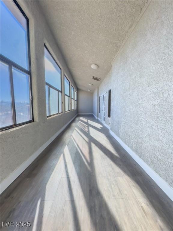 corridor with hardwood / wood-style floors and plenty of natural light