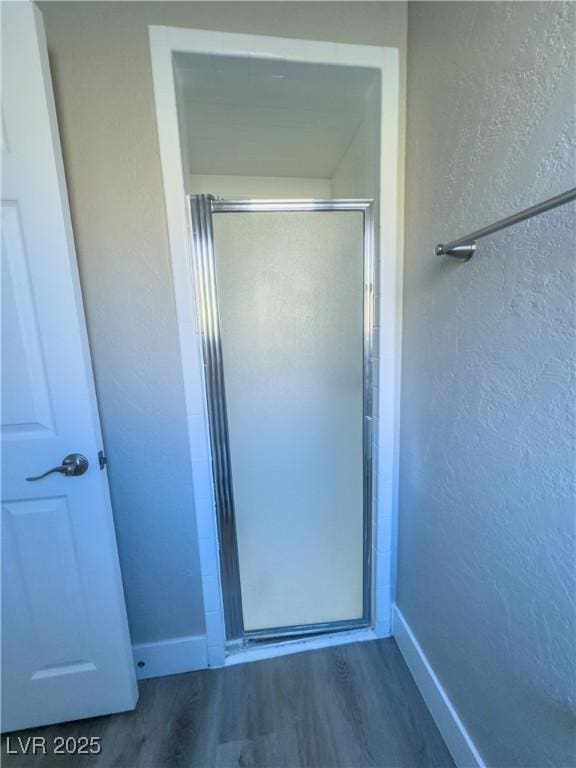 bathroom featuring wood-type flooring and walk in shower