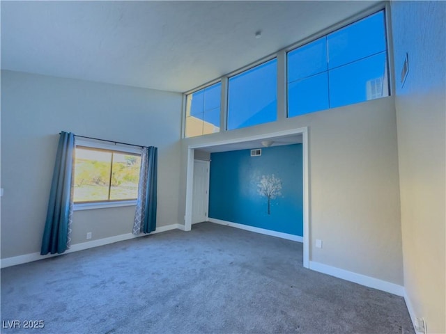 carpeted empty room with a towering ceiling