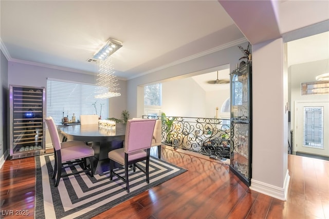 dining space featuring an inviting chandelier, crown molding, beverage cooler, and wood-type flooring