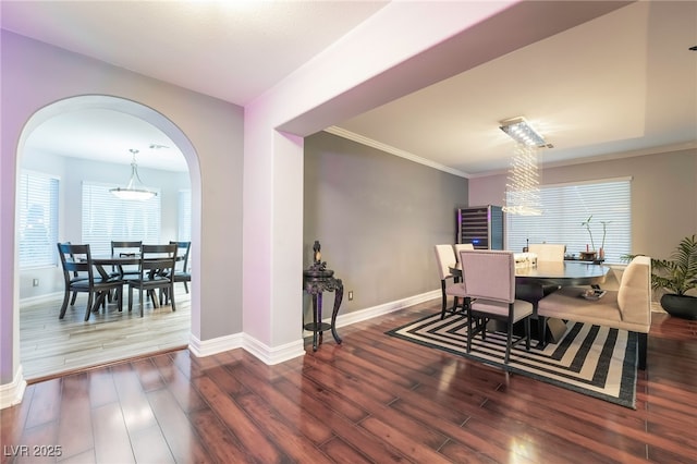 dining room with an inviting chandelier, dark hardwood / wood-style flooring, and crown molding