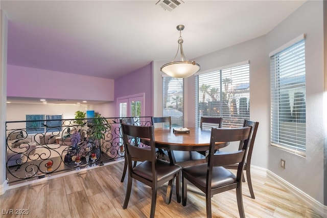 dining room with light wood-type flooring and french doors