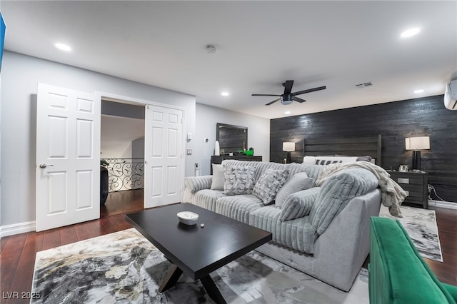 living room with ceiling fan, dark wood-type flooring, and wooden walls