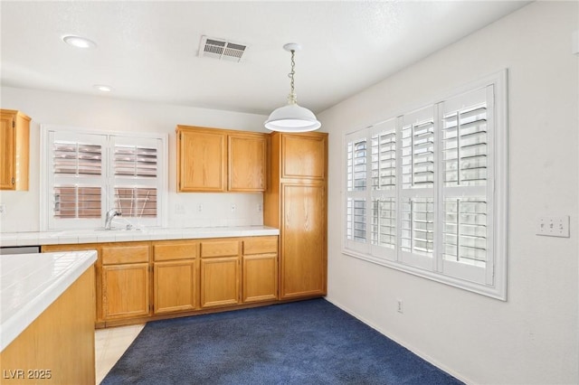 kitchen featuring sink, pendant lighting, light carpet, and tile countertops