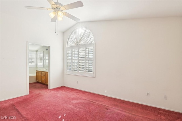 unfurnished bedroom with ceiling fan, vaulted ceiling, connected bathroom, and carpet flooring