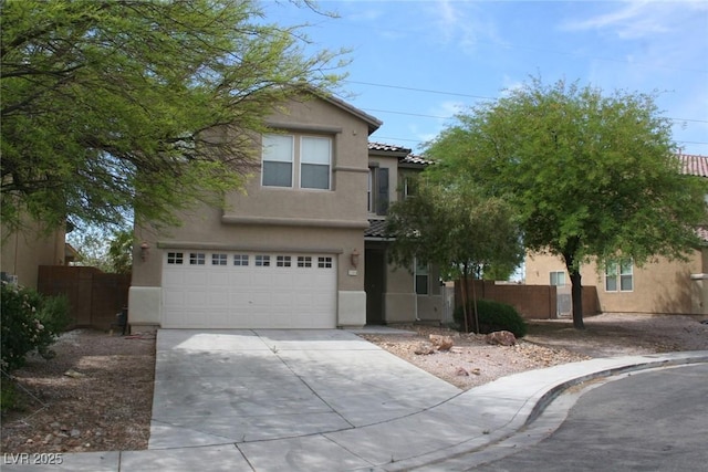 view of front of home with a tiled roof, fence, driveway, and stucco siding