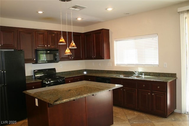 kitchen with decorative light fixtures, a center island, black appliances, sink, and dark stone counters