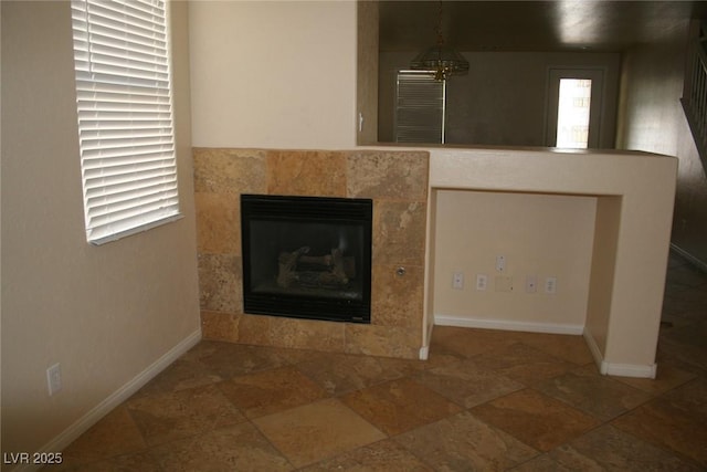 details with a tiled fireplace and a chandelier